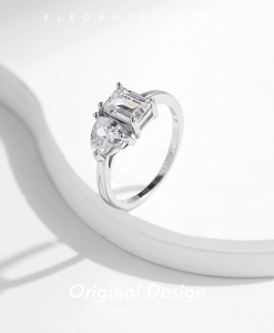 Detail of silver ring featuring emerald-cut and pear-shaped crystals on geometric stand