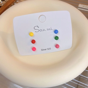 Close-up of 6 colorful round stud earrings with 925 silver needles on display tray