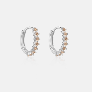 Detailed macro view of S925 sterling silver hoop earrings set with orange cubic zirconia stones