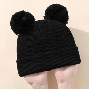 Kids black knit beanie featuring double faux fur pom poms and classic ribbed texture