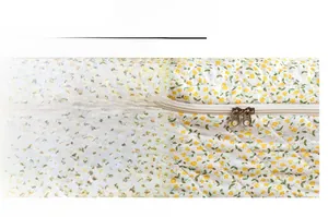 Detail view of the smooth dual zippers and diamond quilted floral cotton fabric