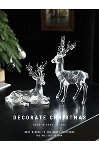 Detail of two transparent acrylic reindeer ornaments with elegant reflection and Christmas tree
