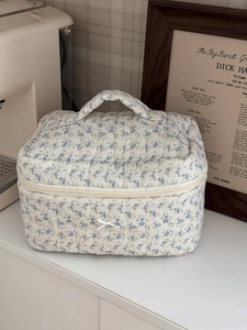 Detail of floral quilted cotton makeup bag with blue flowers and silk ribbon bow