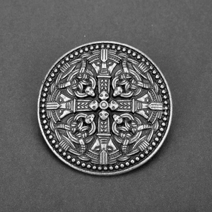 Macro view of Nordic Viking shield brooch featuring ancient silver embossed mythical beasts
