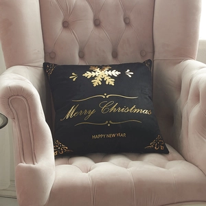 Black velvet Christmas pillow cover with gold snowflakes on a pink velvet chair
