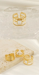 Détail de bagues géométriques évidées plaquées or 18 carats avec émail blanc et superposition