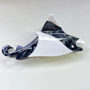 Détail de la pince à cheveux requin noir et blanc avec texture marbrée en acétate