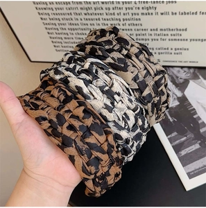 Detailed view of braided leopard print headbands in brown and gray fabric textures