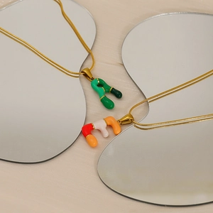 Détails des pendentifs en émail coloré sur chaînes serpent dorées sur miroirs