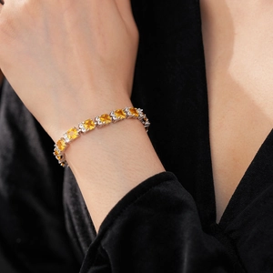Detalle de pulsera con circonita amarilla cuadrada y piedras blancas en base plata