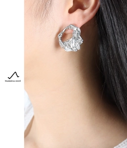 Close-up of a silver irregular wrinkled earring made of durable stainless steel