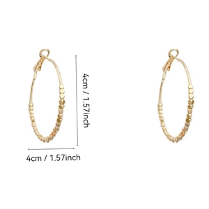Detail von 4 cm goldenen Creolen mit kleinen Perlen auf weißem Hintergrund