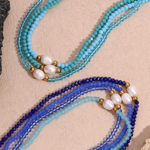Detail view of multi-layered beaded necklace with blue crystals and freshwater pearls