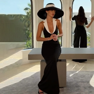 Detail of elegant black backless dress with white lapel collar and slit hem