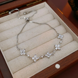 Details des verstellbaren Silberarmbands mit Zirkonia-Blüten in einer hölzernen Schmuckbox
