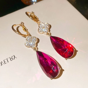Macro shot of rose red teardrop crystal earring with diamond clover detail