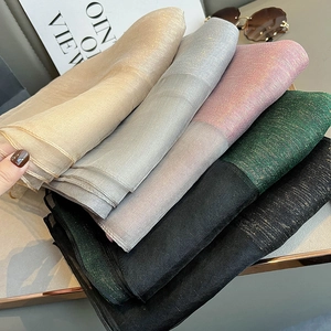 Stack of shimmering mulberry silk scarves in gold silver pink green and black colors