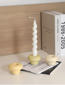Close-up of minimalist mushroom ceramic candle holders with spiral wax candles