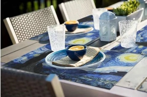 Detail view of Van Gogh Starry Night PVC placemats set on an outdoor wooden table