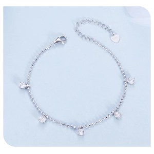 Detail of silver S925 bracelet with five sparkling zircons and a heart pendant