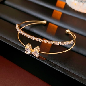 Detail of gold double-layer butterfly bracelet with zircon inlay on a black display stand