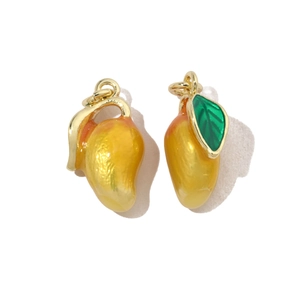 Close-up of mango fruit charms with yellow enamel finish and golden metal loops
