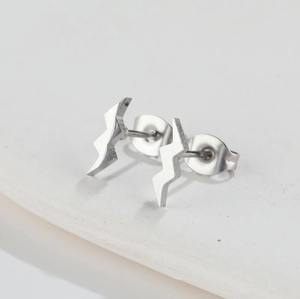 Macro detail of silver geometric lightning bolt stud earrings with butterfly backings