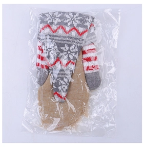 Detail of knitted Santa wine bottle cover with snowflake patterns in festive colors