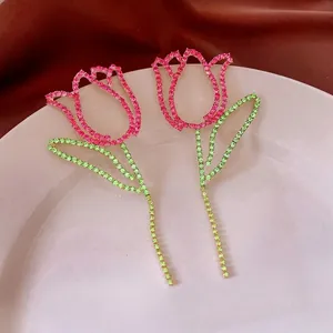 Elegant hollow tulip stud earrings with pink and green crystals in gold finish