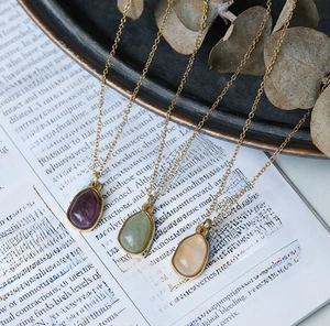 Detailed macro view of three teardrop gemstones set in 18K gold plated titanium steel
