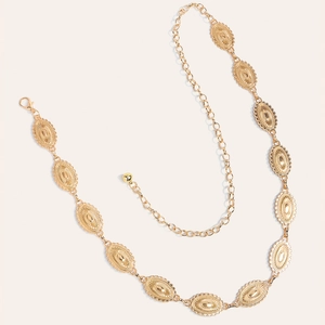 Detailed close-up of vintage golden metal waist chain featuring engraved oval link texture