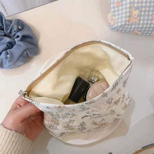 Detailed interior of a floral cotton makeup bag with a cute duck print and zipper closure