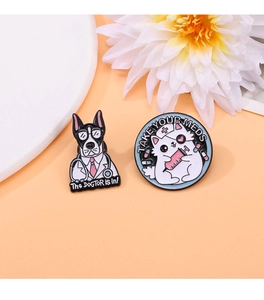 Detail of enamel cat nurse and dog doctor pins on a minimalist warm orange backdrop
