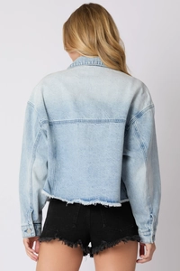 Back view of light blue denim jacket with raw hem and stylish seam details for women