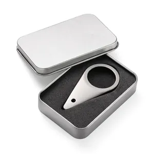 Close-up of teardrop metal bottle opener in rectangular tin box with foam insert