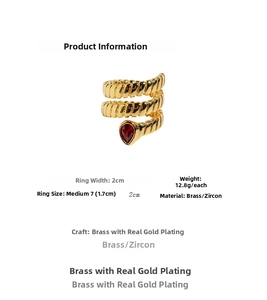 Detail of gold-plated snake ring with textured layers and red teardrop zircon gemstone