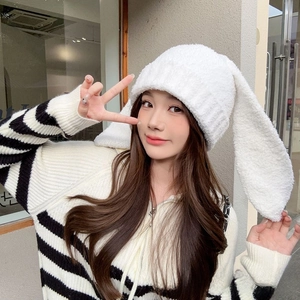 Detailed close-up of fluffy white rabbit-ear plush hat made of high-density faux fur material
