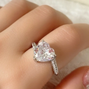 Primer plano de un anillo de corazón en turmalina rosa plateada con circonitas brillantes
