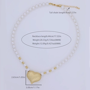 Pearlescent beaded necklace with a matte gold heart pendant and adjustable chain extender