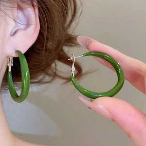Detailed view of green resin drip glaze C-shaped hoop earrings with a glossy metal finish