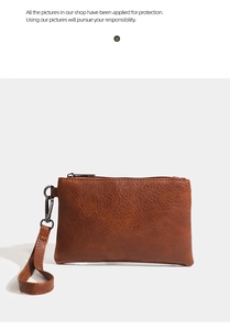 Detail of lychee textured brown PU leather wallet with top zipper and wrist strap