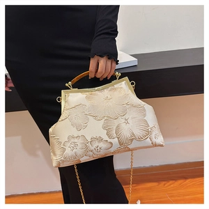 Detail of vintage champagne satin handbag with floral embroidery and wooden handle