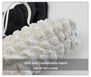 Detailed macro shot of white pleated cloud bag with soft textured bubble fabric finish