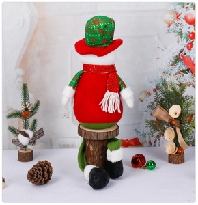 Rear view of plush snowman doll with sequined scarf on wood stand for Christmas decor