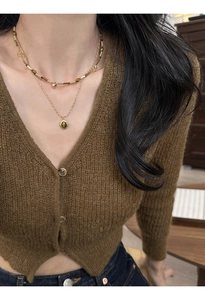 Close-up of double-layer gold necklace featuring a polished tiger eye stone oval pendant