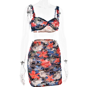 Detail of floral lace two-piece set featuring cropped halter top and ruched mini skirt