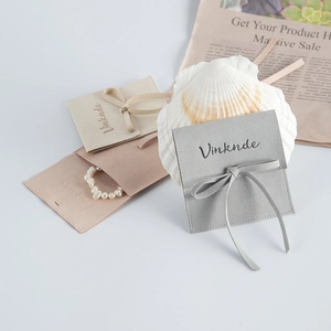 Detail of microfiber suede jewelry pouches with decorative bow and Vinknde branding