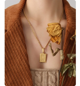 Dettaglio di una collana in acciaio inossidabile dorato con pendente rettangolare W