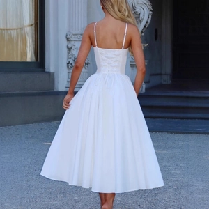 Robe midi blanche élégante à dos nu avec laçage style corset et jupe trapèze fluide