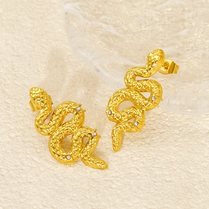 Detail of gold snake earrings with cubic zirconia stones and textured scale patterns